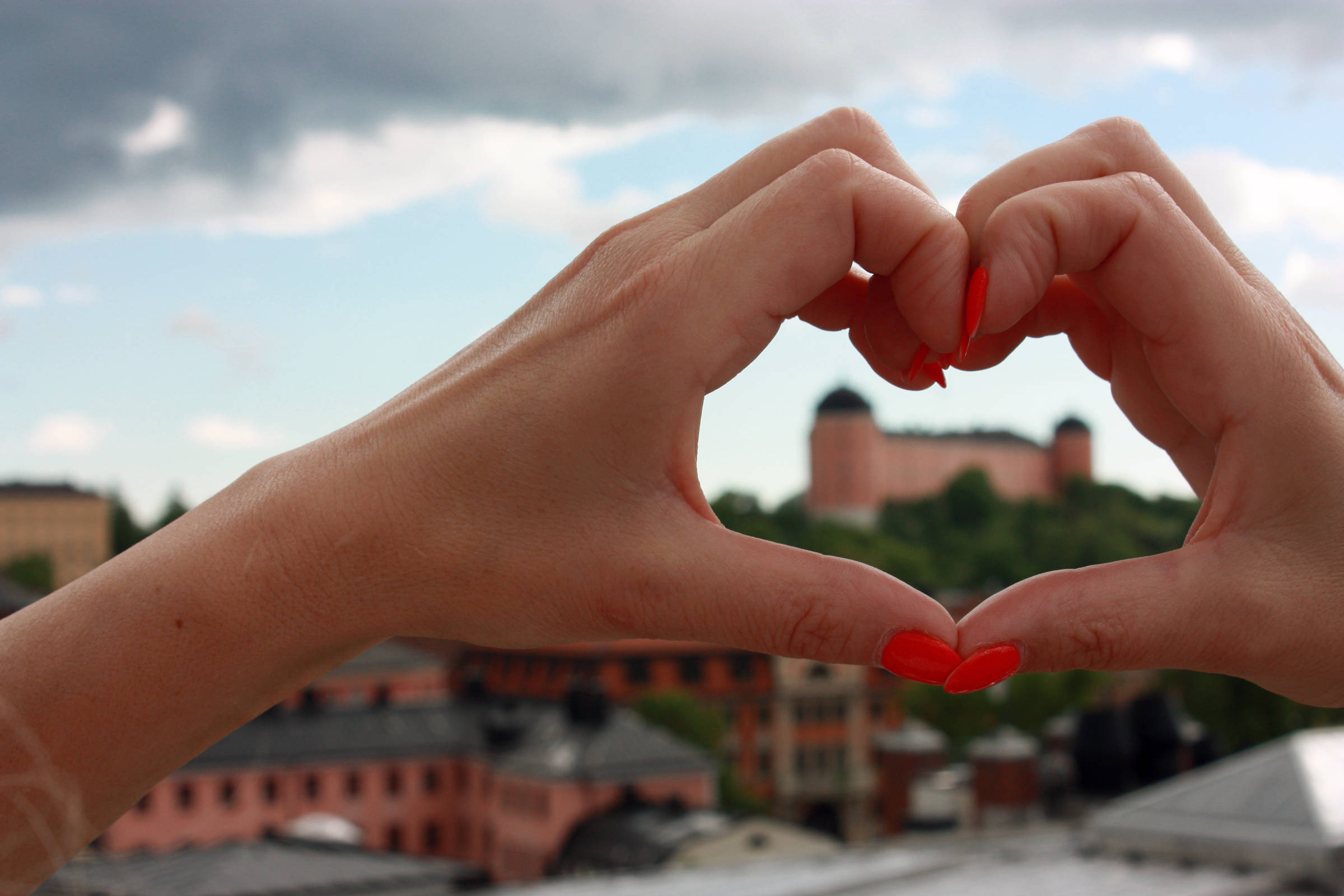 Händer som formar ett hjärta framför Uppsala domkyrka